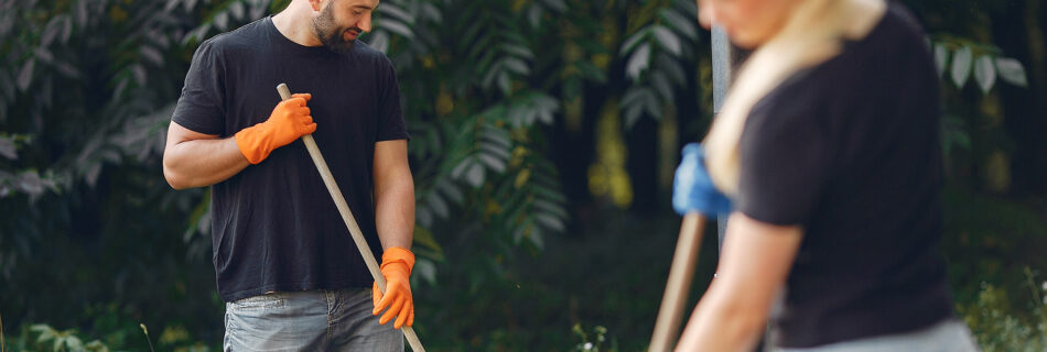 couple collects leaves and cleans the garden